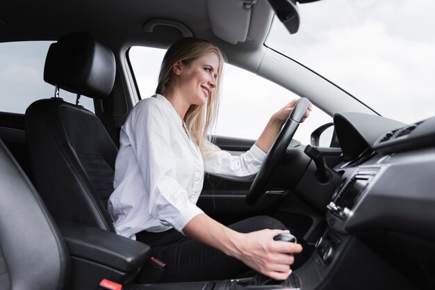 Low angle of a blonde woman driving