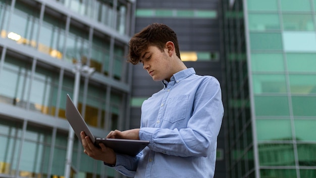 Free photo low angle boy holding laptop