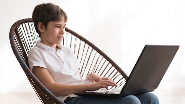 Free photo low angle boy using laptop