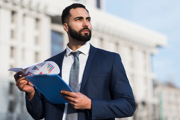 Low angle business man with clipboard