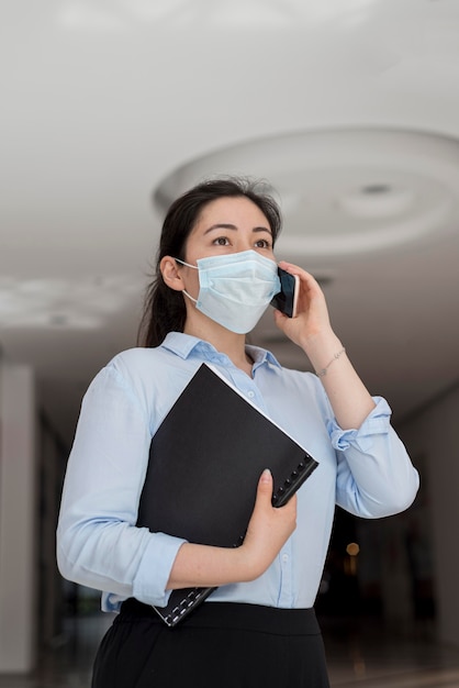 Low angle business woman wearing mask