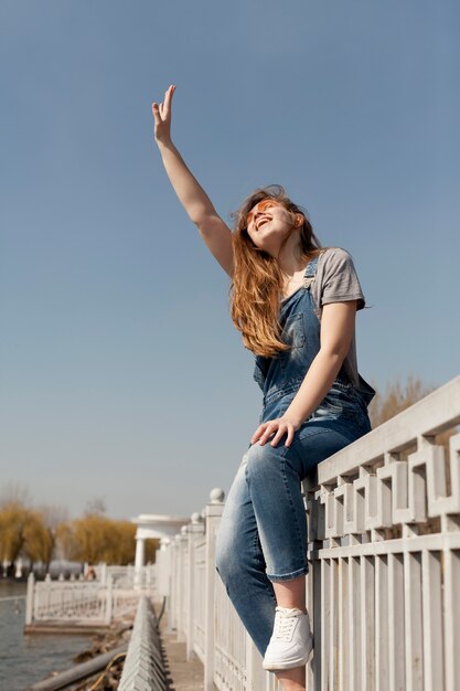 Low angle of of carefree woman posing on railing