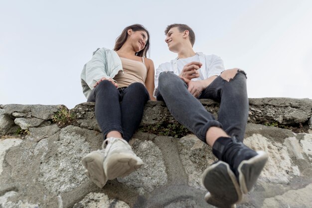 Free photo low angle of cute couple relaxing together outdoors