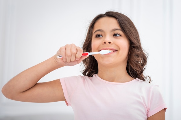 Low angle cute girl brushing theets