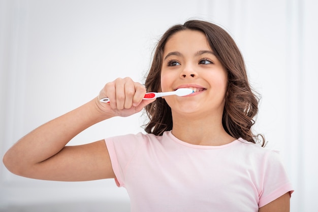 Низкий угол милая девушка чистит зубы