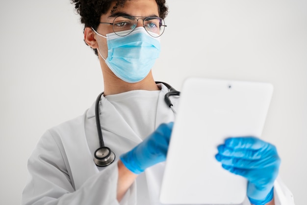 Free photo low angle doctor holding tablet