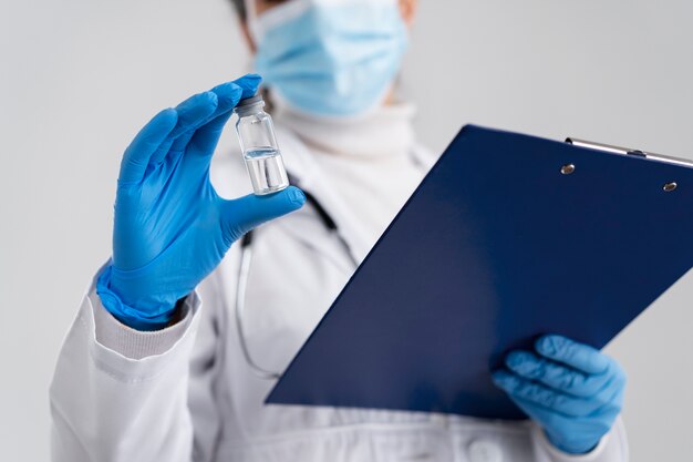 Low angle doctor holding vial