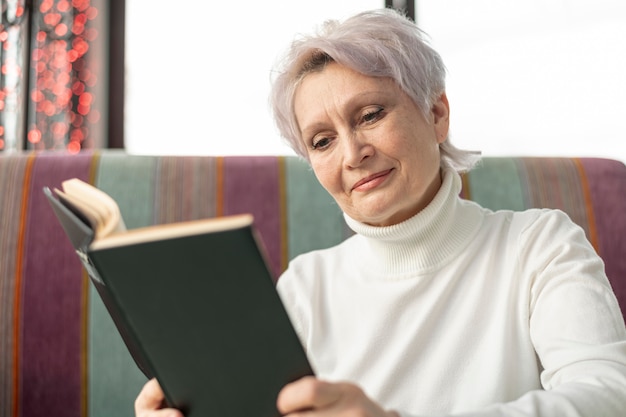 低角度の高齢者の女性の読書