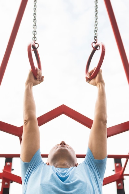 Free photo low angle of elder man exercising outdoors