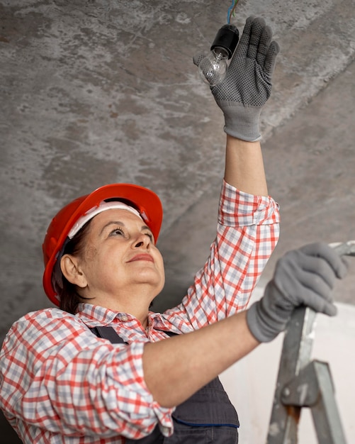 ヘルメットと手袋を持つ女性の建設労働者の低角度