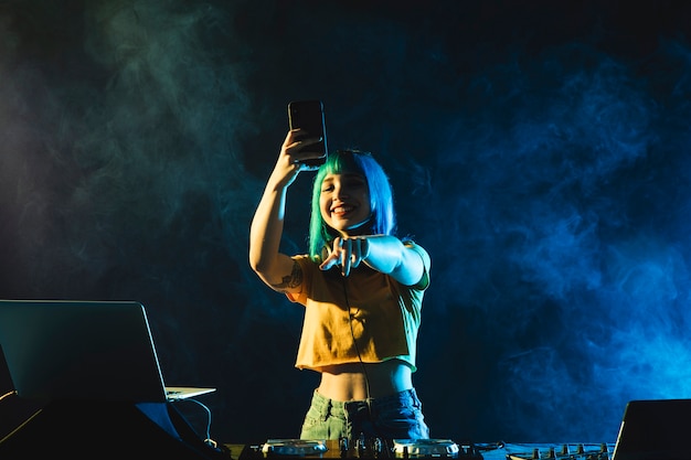 Free photo low angle female dj engaging the crowd