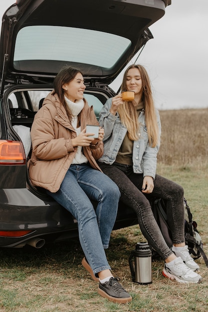 Low angle females chatting and drinking tea