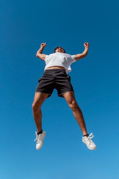 Low angle fit man jumping outdoors