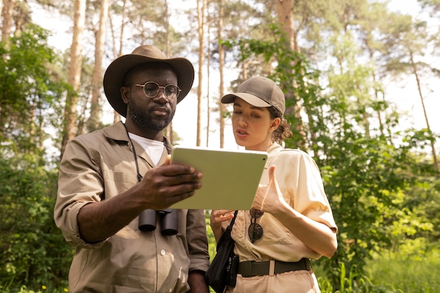 태블릿이 있는 로우 앵글 산림 감시자