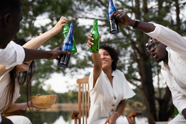 Low angle friends clinking bottles