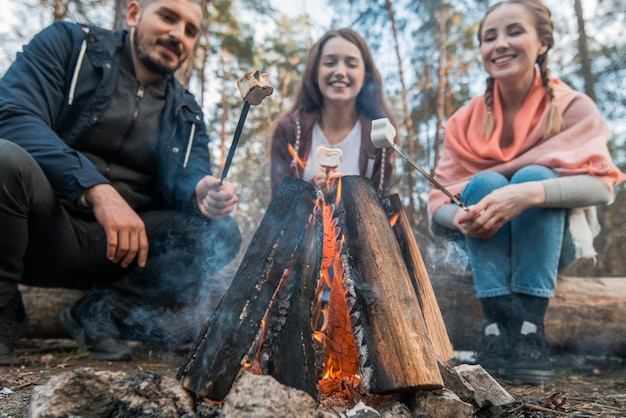 Free photo low angle friends eating marshmallow