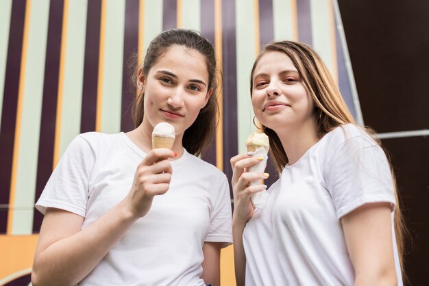 Amici di angolo basso con il gelato che guarda l'obbiettivo