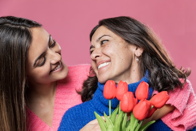 Low angle girl surprising mom with flowers