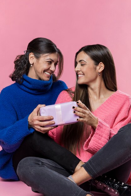 Low angle girl surprising mom with gift