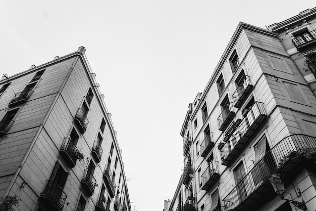 Low angle greyscale shot of residential buildings opposite each other