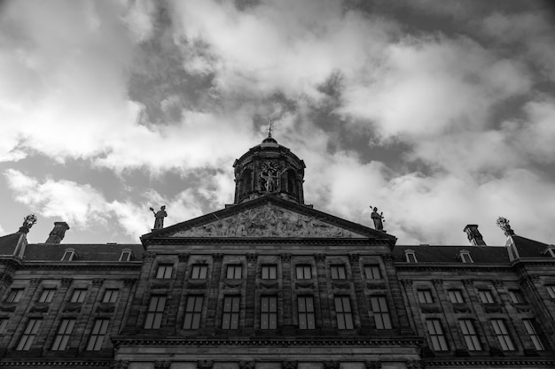 Low angle greyscale shot of the Royal Palace at the Dam Square in Amsterdam, Netherlands