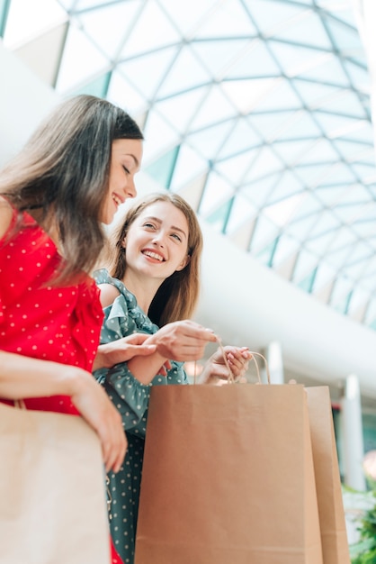 Amici felici di angolo basso al centro commerciale