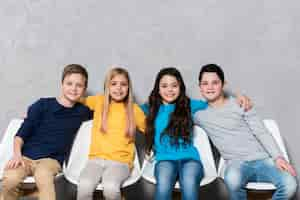 Free photo low angle kids sitting on chairs