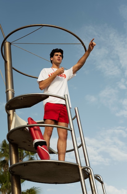 Free photo low angle lifeguard alerting people