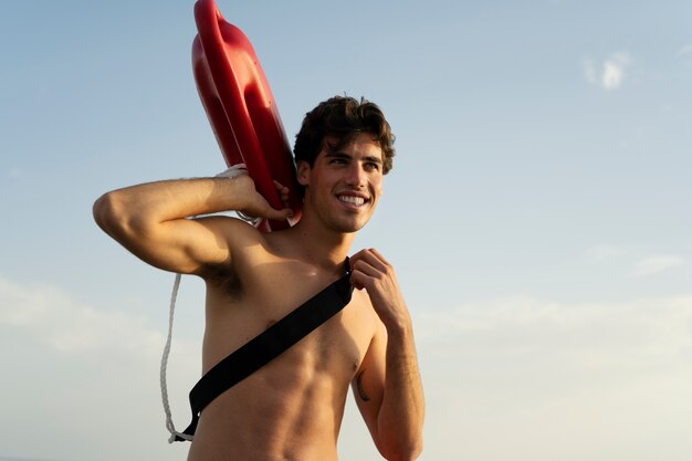Low angle lifeguard holding lifesaving buoy