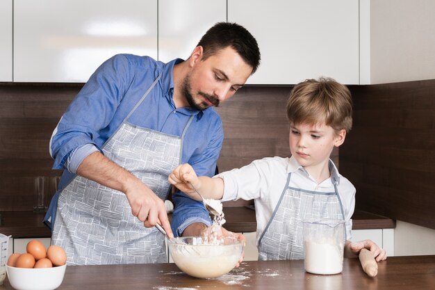 低角度の幼い息子が台所でお父さんを支援