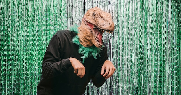 Foto gratuita maschio basso angolo in costume di dinosauro