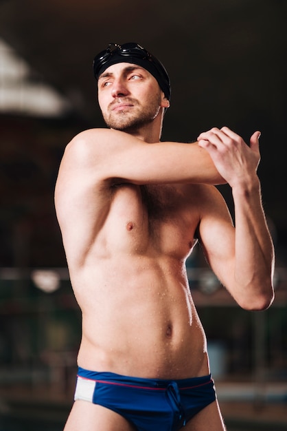 Low angle male swimmer stretching