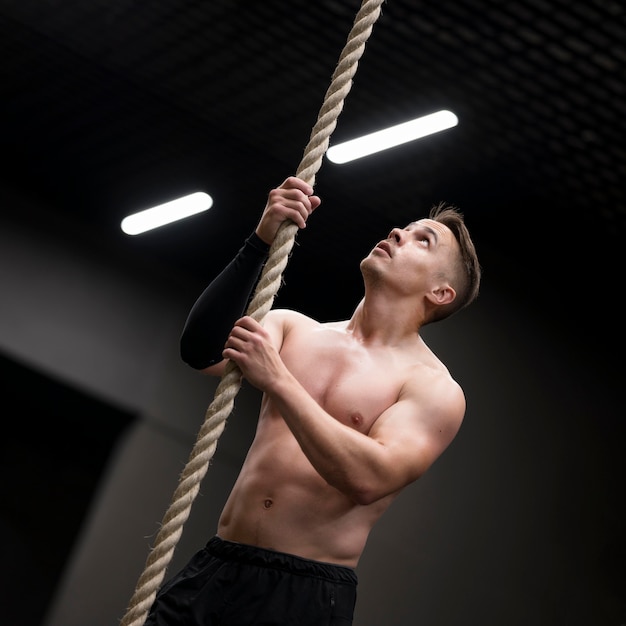 Low angle man climbing on rope