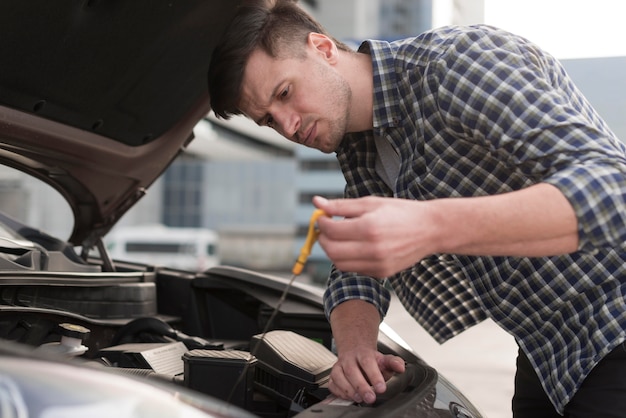 Low angle man fixing car