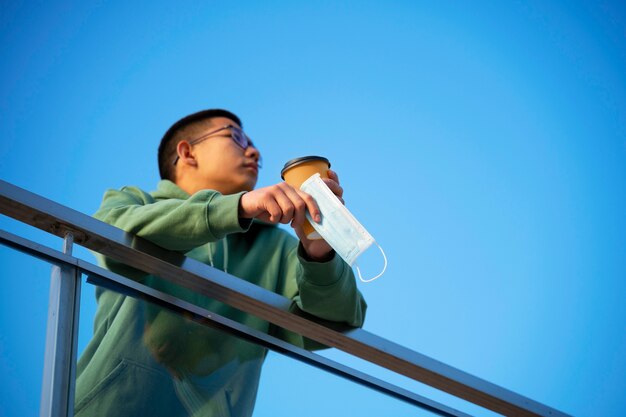 Low angle man holding coffee cup