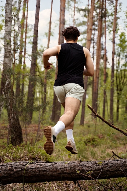 Low angle man jumping over log