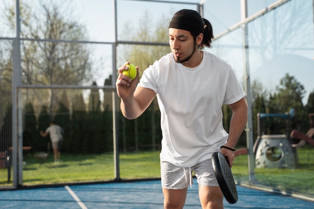 Foto gratuita uomo di angolo basso che gioca a paddle tennis