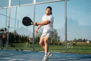 Foto gratuita uomo di angolo basso che gioca a paddle tennis