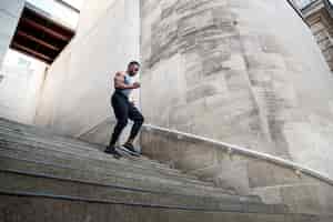Foto gratuita uomo di angolo basso che corre giù per le scale