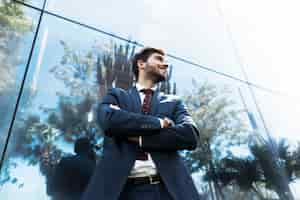 Free photo low angle man standing with crossed arms