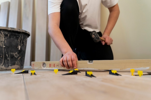 Free photo low angle man tiling floor