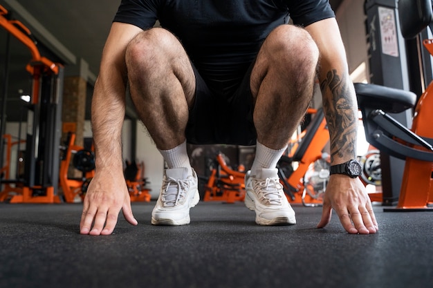 Foto gratuita allenamento uomo ad angolo basso in palestra