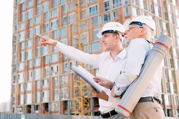 Low angle man with helmet pointing at something