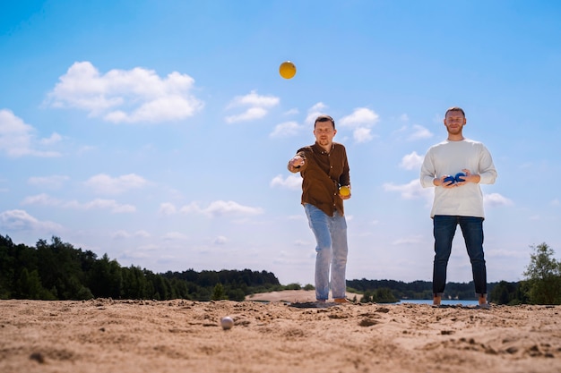 Low angle men playing game at beach