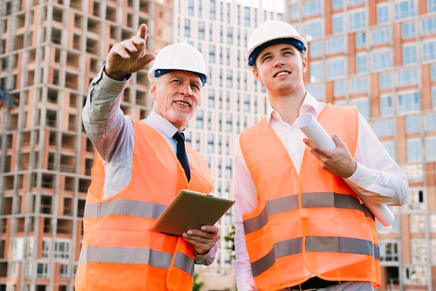 Free photo low angle men with safety vests