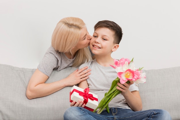 Бесплатное фото Низкий угол мать целует сына за подарки