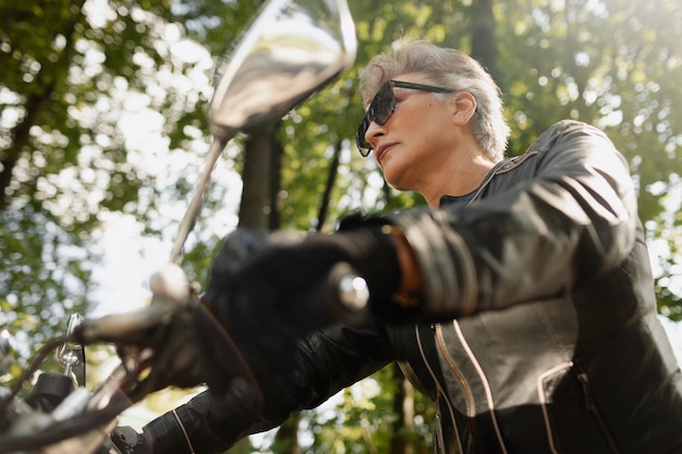 Free photo low angle old woman with cool motorcycle