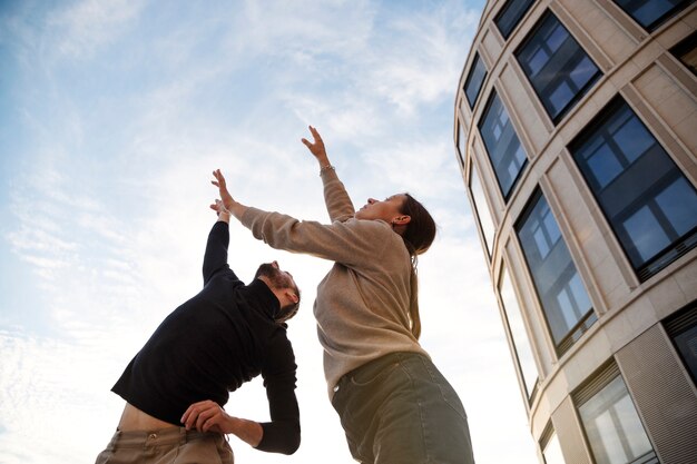 Low angle people dancing together outdoors