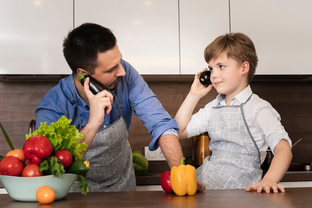 Low angle playful father and son in kitchen