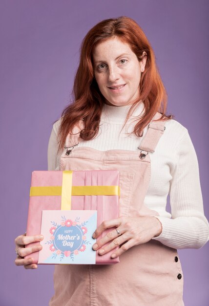 Low angle pregnant female holding gift and greeting card